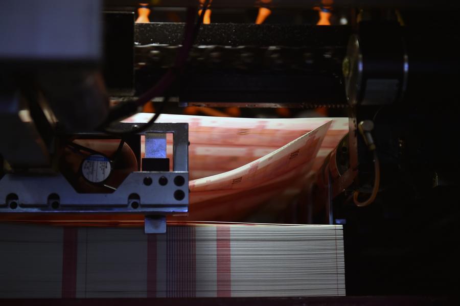 43 armored cash-in-transit vans wait in line to transport new 100-yuan banknotes