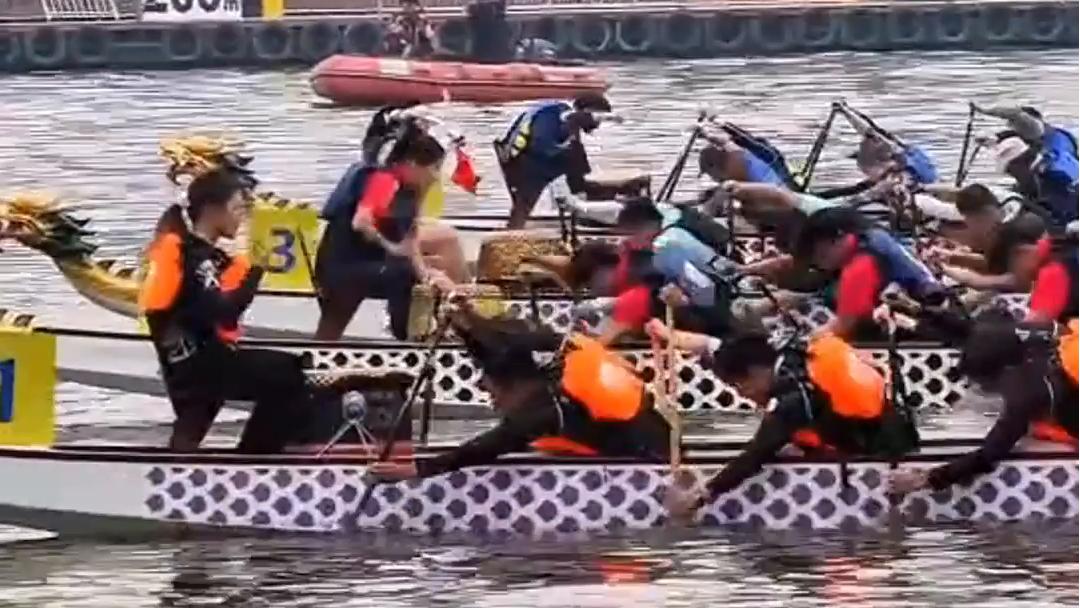 Paddles in motion as dragon boats charge down canal