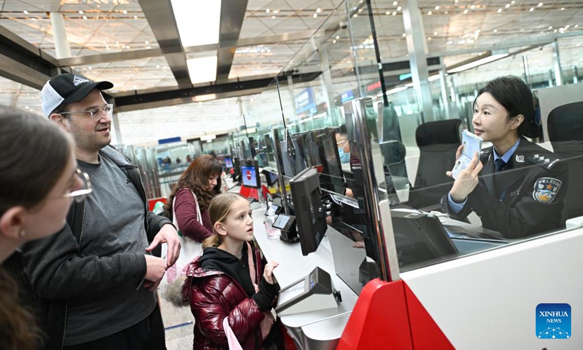 Immigration officer Chen Miao (1st R) handles transit visa exemption procedures for tourists from the USat the immigration area of Beiing Capital lnternational Airport in Beijing, capital of China, Jan. 28, 2025. Photo: Xinhua
