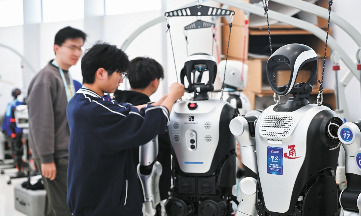 Engineers inspect a humanoid robot at the 2025 Zhongguancun Forum Annual Conference on March 27, 2025. Photo: Tao Mingyang/GT