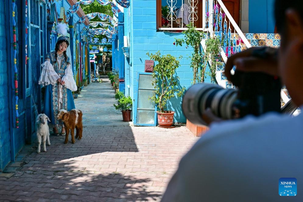 A tourist poses for photos on the Liuxing Street in Yining City, Ili Kazak Autonomous Prefecture, northwest China's Xinjiang Uygur Autonomous Region, May 10, 2024.(Photo: Xinhua)