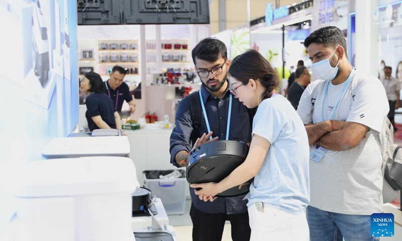Buyers learn about a floor cleaning robot during the 137th edition of the China Import and Export Fair in Guangzhou, south China's Guangdong Province, April 16, 2025. The 137th edition of the China Import and Export Fair, also known as the Canton Fair, kicked off on Tuesday, with the number of export exhibitors exceeding 30,000 for the first time in the history of this famous event. Products reflecting concept of green innovation, including intelligent energy-saving devices and eco-friendly technology products, have garnered favor of foreign merchants during the fair. (Photo: Xinhua)